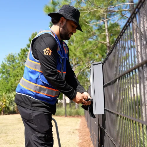 Technician performing pooper scooper service in a Tampa dog park.